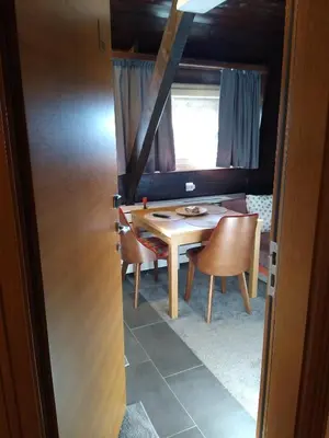 a dining room with a table and chairs and a window at Megi apartman - Konaci Maglic in Kopaonik