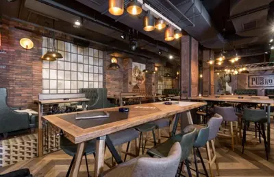 a restaurant with a large wooden table and chairs at Megi apartman - Konaci Maglic in Kopaonik