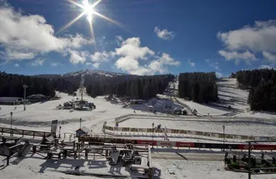 a snow covered ski slope with a train on it at Megi apartman - Konaci Maglic in Kopaonik