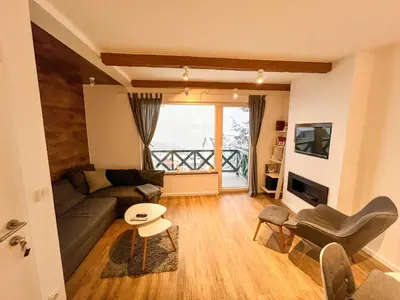 a living room with a couch and a table at Apartment A6 Kopaonik in Kopaonik