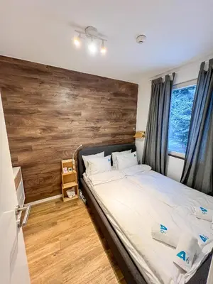 a bedroom with a large bed with a wooden headboard at Apartment A6 Kopaonik in Kopaonik