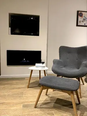 a living room with a chair and a table at Apartment A6 Kopaonik in Kopaonik