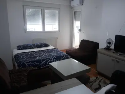 a bedroom with a bed and a couch and a table at Apartman Vranje in Vranje