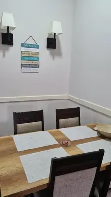 a dining room table with two chairs and a sign on the wall at Apartman No1,Župa Wellness & Spa Kopaonik in Kopaonik