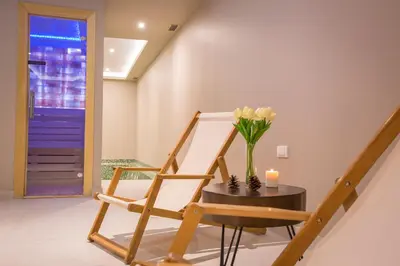 a room with a chair and a table with a vase of flowers at SREBRNA PLANINA Spa & Resort in Kopaonik