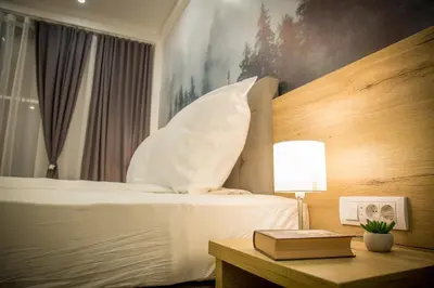 a hotel room with a bed and a table with a lamp at SREBRNA PLANINA Spa & Resort in Kopaonik