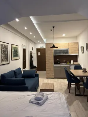 a living room with a blue couch and a kitchen at Kopaonik Apartmani Milmari - Katic in Kopaonik