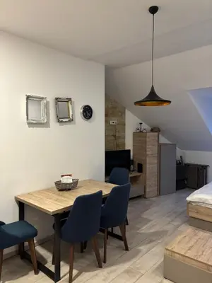 a living room with a dining room table and chairs at Kopaonik Apartmani Milmari - Katic in Kopaonik