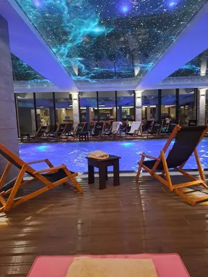 a pool with chairs and a table and a ceiling with stars at Kopaonik Apartmani Milmari - Katic in Kopaonik