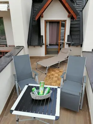 a patio with two chairs and a table with a bowl at Kopaonik Apartmani Milmari - Katic in Kopaonik