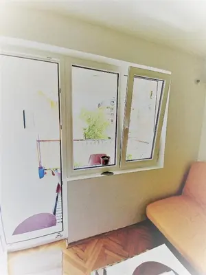 a living room with two windows and a couch at Mist8 in Soko Banja