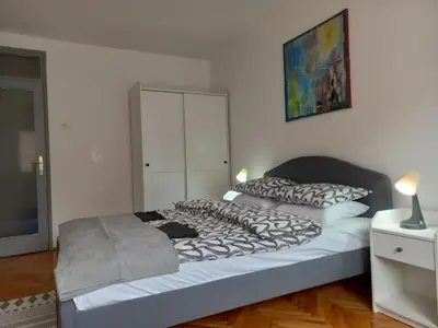 a bedroom with a large bed with a white wall at Mist8 in Soko Banja