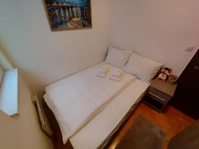 a small bed in a small room with a picture on the wall at Apartman Dream,Kraljevi Čardaci, sa besplatnim parkingom u garazi in Kopaonik