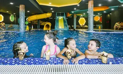 three children are sitting in a swimming pool at Apartman Dream,Kraljevi Čardaci, sa besplatnim parkingom u garazi in Kopaonik