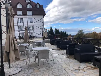 a patio with tables and chairs in front of a building at Apartman Dream,Kraljevi Čardaci, sa besplatnim parkingom u garazi in Kopaonik