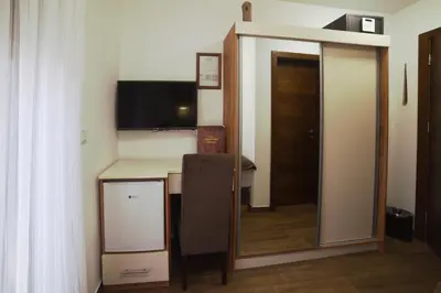 a room with a desk with a television and a mirror at 