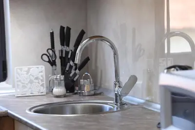 a kitchen counter with a sink with a kitchen utensils at 