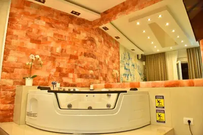a bathroom with a bath tub in front of a brick wall at Design Apartment PREMIUM SPA LUX 4 STAR 