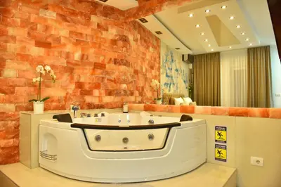 a bath tub in a room with a brick wall at Design Apartment PREMIUM SPA LUX 4 STAR 
