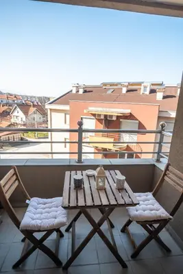 a wooden table and two chairs on a balcony at Apartman Paradiso 211 in Vrnjačka Banja