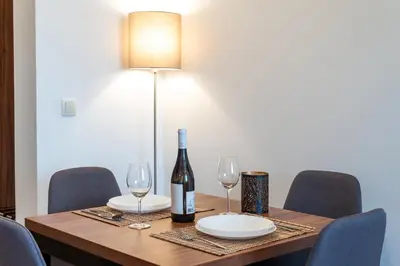 a table with a bottle of wine and two glasses at Apartman Paradiso 211 in Vrnjačka Banja