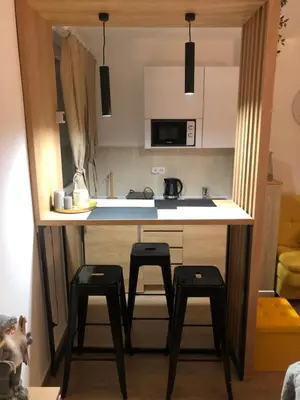 a kitchen with a counter with three stools under it at TeonaLux Kraljevi Cardaci 5a/22 in Kopaonik