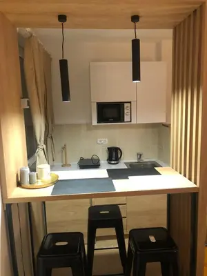 a kitchen with a counter with two stools and a sink at TeonaLux Kraljevi Cardaci 5a/22 in Kopaonik