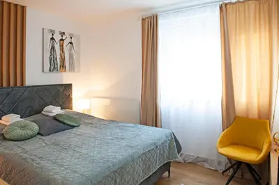 a bedroom with a bed and a yellow chair at TeonaLux Kraljevi Cardaci 5a/22 in Kopaonik