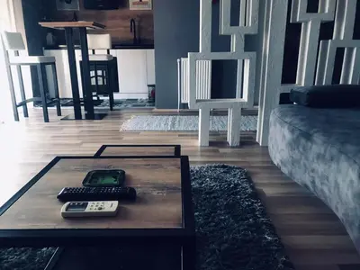 a living room with a table with a remote control on it at Bubinga in Kruševac