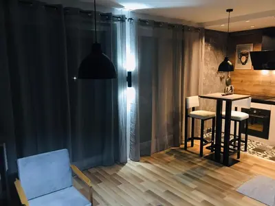 a living room with a dining room table and chairs at Bubinga in Kruševac