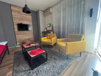 a living room with two yellow chairs and a table at Bubinga in Kruševac