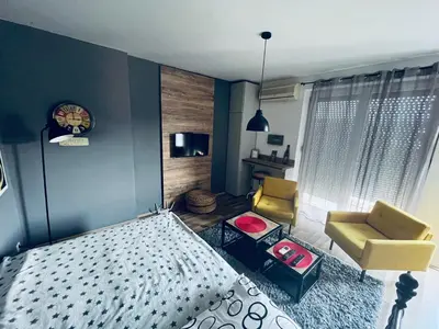 a bedroom with a bed and a couch and a chair at Bubinga in Kruševac