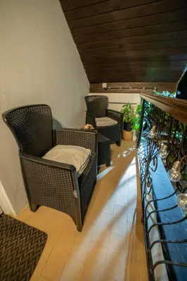 a balcony with wicker chairs and a table at Vila Jezerski raj Borsko jezero in Bor