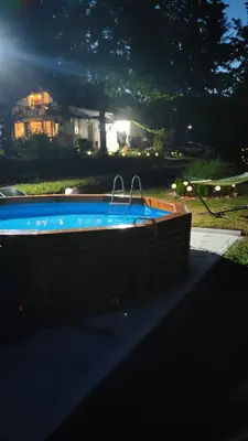 a swimming pool with two faucets in a yard at night at Vila Jezerski raj Borsko jezero in Bor