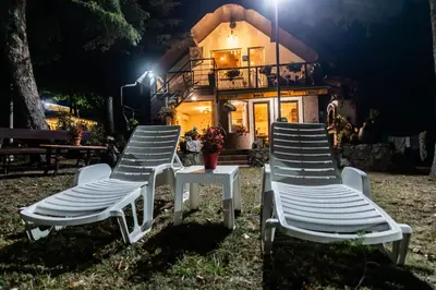 two chairs and a table in front of a house at Vila Jezerski raj Borsko jezero in Bor