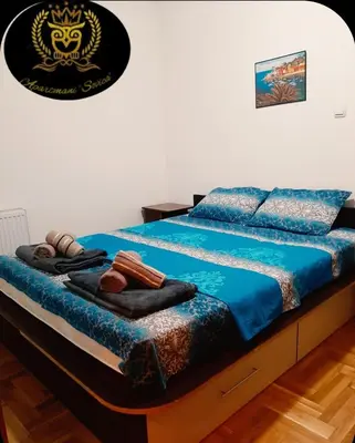 a bed with blue sheets and towels on it at Apartmani Sovica in Vrnjačka Banja