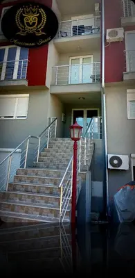 a building with stairs and a red lamp in front of it at Apartmani Sovica in Vrnjačka Banja