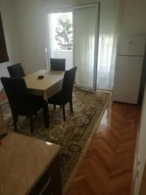 a dining room with a table and chairs and a kitchen at STAN na DAN PEX FREE PARKING in Vranje