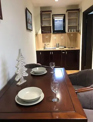 a dining room table with a christmas tree on it at Mecava Apartmani in Kopaonik