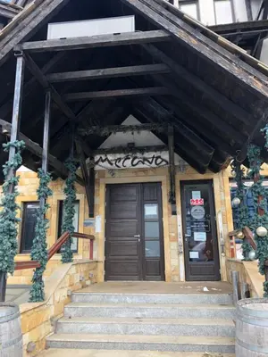 a building with stairs leading up to a door at Mecava Apartmani in Kopaonik