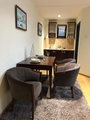 a dining room with a table and two chairs at Mecava Apartmani in Kopaonik