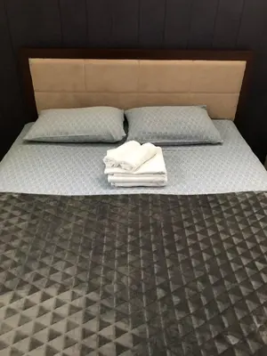 a bed with two pillows and two towels on it at Mecava Apartmani in Kopaonik