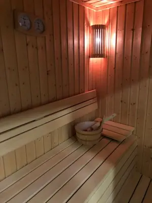 a sauna with a basket and a clock on the wall at Mecava Apartmani in Kopaonik