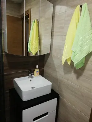 a bathroom with a sink and a mirror and towels at Apartman Alba in Kopaonik