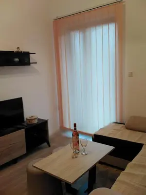 a living room with a table with a bottle and glasses at Apartman TiA Vrnjacka Banja in Vrnjačka Banja