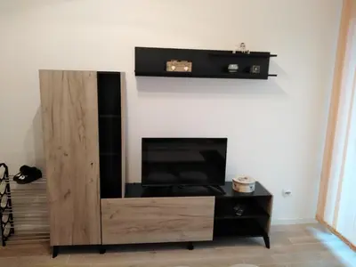 a wooden entertainment center in a living room at Apartman TiA Vrnjacka Banja in Vrnjačka Banja