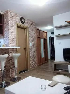 a living room with a clock on a brick wall at Kopaonik,Sunčana dolina,Apart-Pavlovic in Kopaonik