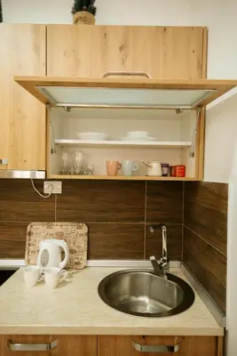 a kitchen counter with a sink and wooden cabinets at Apartman Kostic Kraljev Konak in Kopaonik
