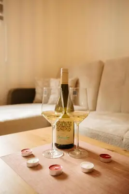 a bottle of wine and two glasses on a table at Apartman Kostic Kraljev Konak in Kopaonik