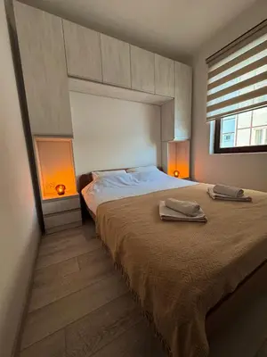 a bedroom with a bed with two lamps on it at Apartman Ema in Kopaonik
